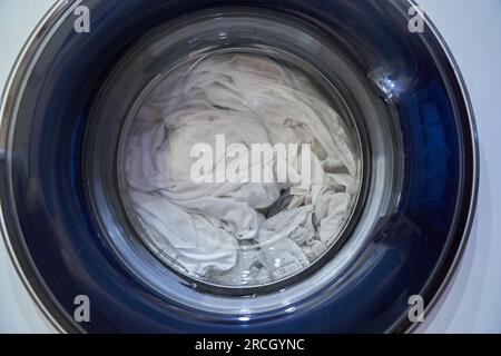 Primo piano mostra come il bucato viene lavato in una lavatrice isolata. Il concetto di elettrodomestici. Foto di alta qualità Foto Stock