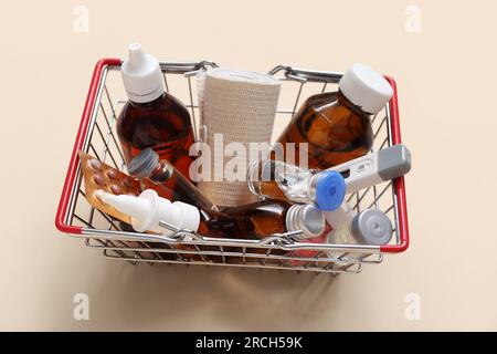 Mini carrello con diversi farmaci su sfondo beige Foto Stock