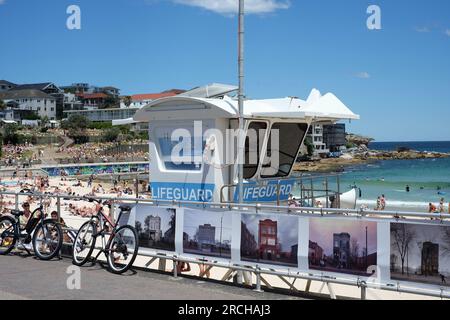 Passeggiata sulla spiaggia di Bondi, rifugio bagnino, banner espositivo di foto di edifici americani, spiaggia e mare - Head on Exhibition 2022 Foto Stock