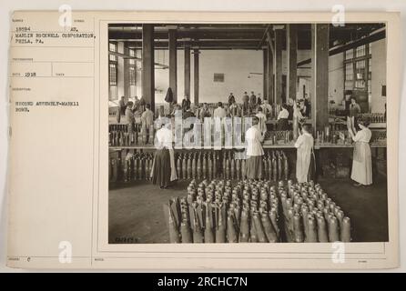 Soldati che assemblano una bomba Mark 11 durante la prima guerra mondiale La foto è stata scattata dalla Marlin Rockwell Corporation a Philadelphia, Pennsylvania, nel 1918. Questa è una descrizione fattuale dell'immagine, che mostra una specifica attività militare durante la guerra. Foto Stock