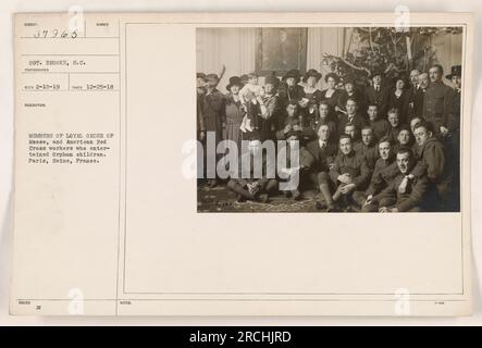 I membri del leale ordine delle alci e i lavoratori della Croce Rossa americana a Parigi, Senna, in Francia, intratterranno i bambini orfani durante la prima guerra mondiale. Questa foto è stata scattata il 25 dicembre 1918. Foto Stock