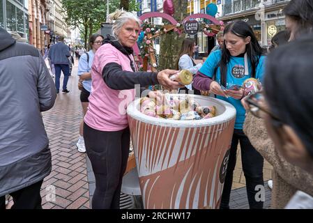 Promozione caffè con assaggi gratuiti consegnati ai passanti presso New Street, Birmingham, Inghilterra, Regno Unito Foto Stock