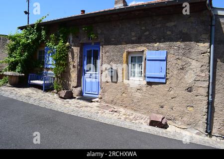 bella vecchia casa in pietra con porte e finestre blu chiaro Foto Stock