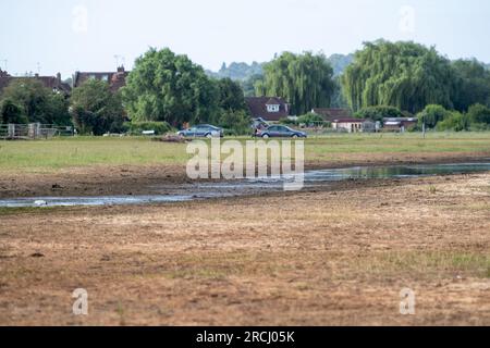 Dorney, Buckinghamshire, Regno Unito. 2 luglio 2023. Le acque alluvionali rimangono a Dorney Common con grande frustrazione degli abitanti del villaggio che vivono a Colenorton Crescent nella vicina Eton Wick. Gli abitanti del villaggio riferiscono che stanno ricevendo un "puzzo di acque reflue”, soprattutto la sera. L'acqua del Tamigi può essere scaricata nel canale Roundmoor accanto al comune; tuttavia, il monitoraggio della durata degli eventi mostra che l'ultima scarica nel canale Roundmoor è avvenuta a gennaio. Una parte dell'acqua alluvionale sta ora cominciando a calare, ma è stata particolarmente negativa nelle ultime settimane nonostante la scarsa pioggia. Credito: Maureen Foto Stock