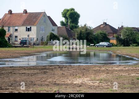 Dorney, Buckinghamshire, Regno Unito. 2 luglio 2023. Le acque alluvionali rimangono a Dorney Common con grande frustrazione degli abitanti del villaggio che vivono a Colenorton Crescent nella vicina Eton Wick. Gli abitanti del villaggio riferiscono che stanno ricevendo un "puzzo di acque reflue”, soprattutto la sera. L'acqua del Tamigi può essere scaricata nel canale Roundmoor accanto al comune; tuttavia, il monitoraggio della durata degli eventi mostra che l'ultima scarica nel canale Roundmoor è avvenuta a gennaio. Una parte dell'acqua alluvionale sta ora cominciando a calare, ma è stata particolarmente negativa nelle ultime settimane nonostante la scarsa pioggia. Credito: Maureen Foto Stock