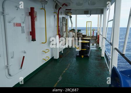 Ingresso alla sovrastruttura bianca della nave mercantile container dal ponte principale dipinto di verde sul lato del porto. Foto Stock