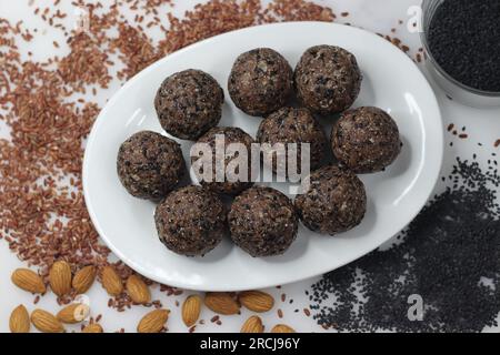 Navara til laddu. Palla dolce fatta di riso navara arrostito e macinato, semi di sesamo arrosto, jaggery e cocco grattugiato aromatizzato al cardamomo. In salute Foto Stock