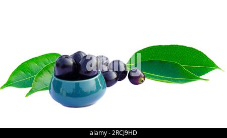 Vista laterale deliziosa jambul selvatica o frutta di jambola con foglie servite in ciotola su sfondo bianco. Foto Stock