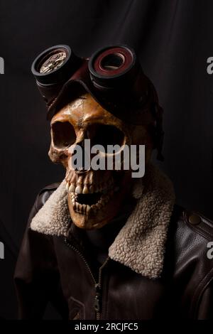 Teschio con giacca in pelle e occhialini steampunk. Costume da aviatore Foto Stock