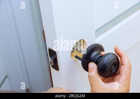 Il lavoratore installa correttamente il blocco sulla nuova portiera interna Foto Stock