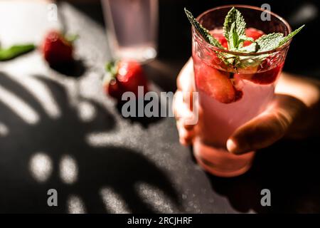 Punch alla limonata di fragole. Un delizioso mix di limonata piccante e fragole succulente, servito in un bicchiere con cubetti di ghiaccio. Il vivace colore rosso e. Foto Stock