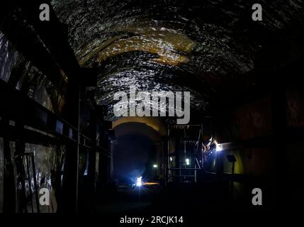 (230715) -- XICHANG, 15 luglio 2023 (Xinhua) -- i lavoratori sono visti nel cantiere della seconda fase del China Jinping Underground Laboratory, nella provincia del Sichuan, nel sud-ovest della Cina, 4 luglio 2023. Il monte Jinping, situato nel bacino idrografico del fiume Yalong, il più grande affluente del fiume Jinsha, ha l'altitudine più alta di 4.410 metri. Il China Jinping Underground Laboratory (CJPL) si trova al centro del tunnel di Jinping lungo 17,5 chilometri nella provincia del Sichuan della Cina sud-occidentale. Il laboratorio, inaugurato nel 2010, è una struttura di ricerca sotterranea con una superficie rocciosa Foto Stock