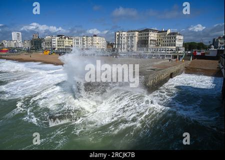 Brighton Regno Unito 15 luglio 2023 - onde enormi si schiantano sulla spiaggia e sul lungomare di Brighton vicino al molo come venti insolitamente forti per le parti batter di luglio del Regno Unito : Credit Simon Dack / Alamy Live News Foto Stock