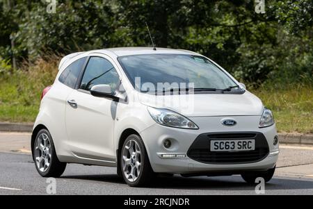 Milton Keynes, Regno Unito - 13 luglio 2023: 2013 auto FORD KA bianca che guida su una strada inglese. Foto Stock