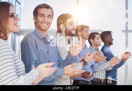 Un team di lavoro felice applaudendo dopo una riunione di successo Foto Stock
