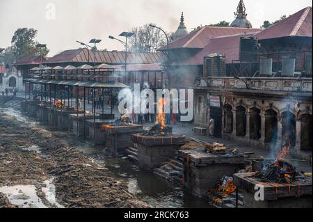 Kathmandu, Nepal - 17 aprile 2023: Un rituale delle Cremazioni indù presso il tempio Pashupatinath e il fiume Bagmati, uno dei più grandi e antichi templi indù di Th Foto Stock