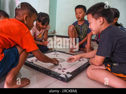 Imphal, India. 14 luglio 2023. I bambini giocano a carote in un campo di soccorso. Il campo di soccorso sta ospitando i residenti della comunità Meitei, le cui case sono state raso al suolo all'inizio della crisi comunitaria in corso. Più di 50.000 persone sfollate per violenza a Manipur sono attualmente ospitate in 349 campi di soccorso. Credito: SOPA Images Limited/Alamy Live News Foto Stock