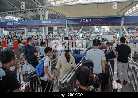 Le persone si mettono in fila e fanno il check-in alla stazione ferroviaria. Guangzhou South Railway Station è una delle più grandi e popolari stazioni ferroviarie della Cina. Ha una posizione ottima, che collega i treni da diverse parti della Cina, tra cui Pechino, Shanghai, Shenzhen, Hong Kong, Changsha, Wuhan e molti altri. Foto Stock