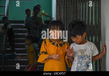 Imphal, India. 14 luglio 2023. Bambini in piedi di fronte a un campo di soccorso. Il campo di soccorso sta ospitando i residenti della comunità Meitei, le cui case sono state raso al suolo all'inizio della crisi comunitaria in corso. Più di 50.000 persone sfollate per violenza a Manipur sono attualmente ospitate in 349 campi di soccorso. (Foto di Biplov Bhuyan/SOPA Images/Sipa USA) credito: SIPA USA/Alamy Live News Foto Stock