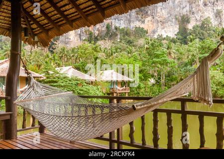 Amaca in una casa di legno con vista sulle montagne e sul lago in un resort naturalistico Foto Stock