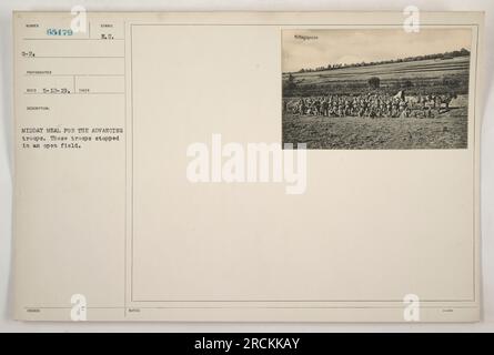 Soldati americani che condividono un pasto di mezzogiorno mentre avanzano durante la prima guerra mondiale Le truppe si sono fermate in un campo aperto per riposarsi e mangiare. La foto è stata scattata dal fotografo Reco il 12 maggio 1919, con la descrizione che indica che i soldati hanno ricevuto i pasti per la pausa di mezzogiorno. Viene anche menzionato il simbolo F.U., forse riferendosi all'unità o all'organizzazione. Foto Stock