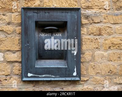 Cassetta di sicurezza notturna obsoleta Lloyds Bank situata in un muro a Broadway, Worcestershire, Inghilterra, Regno Unito Foto Stock