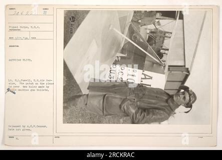 Tenente americano S.L. Powell, un pilota negli Stati Uniti Air Service, si trova accanto al suo aereo danneggiato durante la prima guerra mondiale. Si possono vedere due fori di proiettile da una mitragliatrice, sistemati sul lato dell'aereo. Questa fotografia è stata rilasciata dalle autorità tedesche sotto censura A.E.P. Data di cattura sconosciuta. Foto Stock