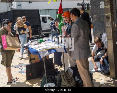 Londra, Regno Unito. 15 luglio 2023. I manifestanti di Hammersmith contro la legge sull'immigrazione illegale distribuiscono volantini e raccolgono firme di petizioni che affermano che si tratta di razzismo, di capro espiatorio e di criminalizzazione dei migranti e dei richiedenti asilo, negando loro i diritti umani fondamentali. Il governo sostiene di essere compassionevole, ma non mostra compassione, con l'intenzione di imprigionare i migranti indipendentemente e deportarli in Ruanda, pur non riuscendo ad affrontare le cause della migrazione. Peter Marshall/Alamy Live News Foto Stock