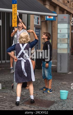 Kaiserslautern, Germania. 15 luglio 2023. Il giovane ragazzo entra a far parte dello spettacolo di strada "Die Zimmermädchen" di Blaumeier. Tre giorni di spettacoli teatrali e musicali di strada forniti da 200 artisti internazionali nel centro della città di Kaiserslautern - giorno 2. Credito: Gustav Zygmund/Alamy News Foto Stock