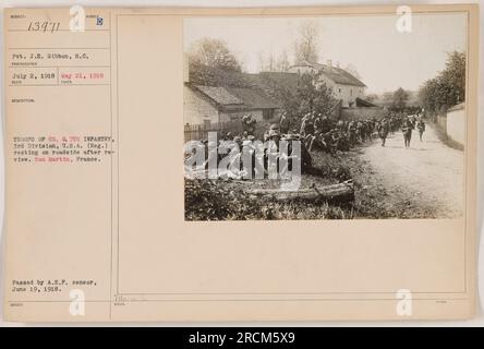 Didascalia: Privata J.E. Gibbon del Signal Corps (SC) è visto riposare sulla strada con i membri della compagnia G, 7th Infantry, 3rd Division, U.S.A. (Regolari) dopo una rivisitazione a San Martin, Francia. Questa foto è stata scattata il 21 maggio 1918 e ricevuta il 2 luglio 1918. In seguito fu consegnato alle truppe. Nota: L'immagine è stata approvata dalla A.E.F. censor il 19 giugno 1918. Foto Stock