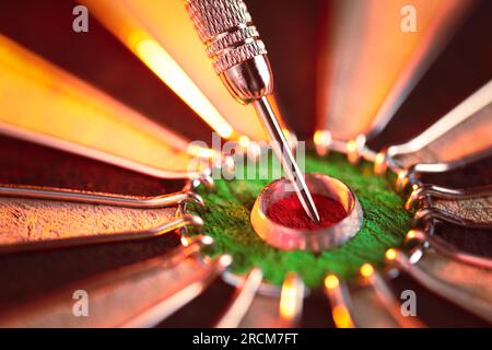 DART board che mostra un dardo che colpisce il torello centrale. Concetto di successo, definizione e raggiungimento di obiettivi mirati e ricerca della perfezione. Foto Stock