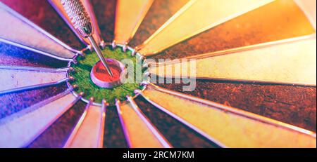 DART board che mostra un dardo che colpisce il torello centrale. Concetto di successo, definizione e raggiungimento di obiettivi mirati e ricerca della perfezione. Foto Stock