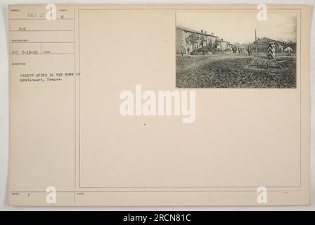 I soldati americani si impegnarono in attività militari a Heudicourt, in Francia, durante la prima guerra mondiale. La fotografia cattura una vivace scena di strada in città, simboleggiando il coinvolgimento del personale militare americano nello sforzo bellico. Scattata il 12 maggio 1919, l'immagine mostra la presenza delle forze americane in Europa. Foto Stock