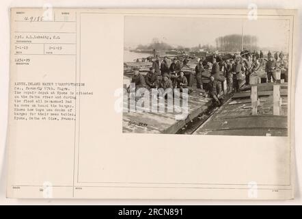 Il personale della 125th Inland Water Transportation Co. (Ex 57th Engrs) presso il deposito di riparazione di Epone, in Francia, si sposta su chiatte durante un'alluvione. L'immagine mostra i soldati che usano il ponte delle chiatte come tavoli da disordine. La foto è stata scattata il 1 marzo 1919 dal fotografo S.G. Corp. A.L. Lubatty può essere visto nella foto. Foto Stock