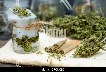 Coni pre-laminati per fumare cannabis con cannabis indica in una bottiglia trasparente Foto Stock