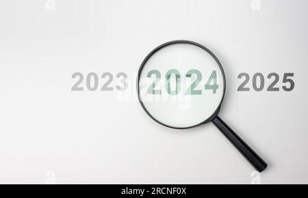 2024 interno della lente d'ingrandimento su sfondo bianco per la messa a fuoco della situazione attuale, lente d'ingrandimento nera con 2024 anni tra il 2023 e il 2025 per la messa a fuoco. 20 Foto Stock