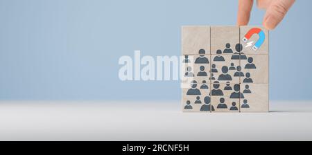 Attrarre clienti online e generare lead Generation. Business Lead e generazione di clienti estrazione del magnete. La mano di un uomo d'affari attira figure umane con un Foto Stock