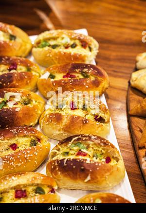 mini pizza con peperoni e mozzarella, finger food, festa di compleanno per bambini, panini, su un tavolo rustico in legno Foto Stock