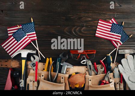 Il banner del Labor Day è un mockup di attrezzi e bandiere su sfondo di legno Foto Stock