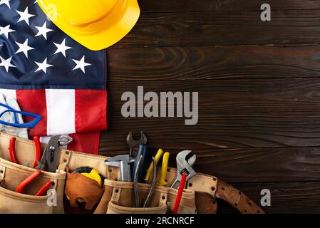 Attrezzi hardHat toolbelt e noi bandiera su sfondo di legno banner del giorno di lavoro mockup Foto Stock