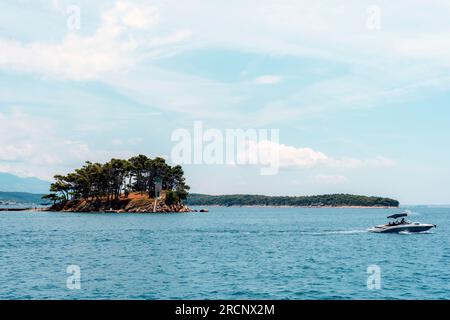 Piccola isola rocciosa sulla spiaggia di Rajska sull'isola di Rab in Croazia. Foto Stock