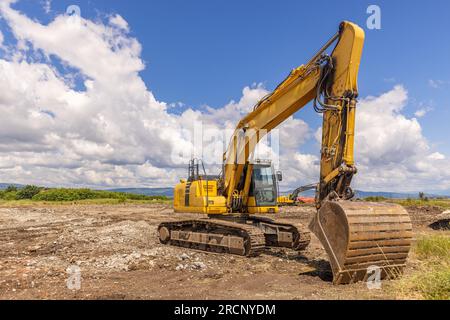 Escavatore in cantiere. Escavatore industriale parcheggiato in cantiere Foto Stock