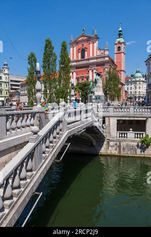 Città di Lubiana in Slovenia dal triplo ponte sul fiume Lubiana con vista sulla chiesa francescana dell'Annunciazione in piazza Preseren. Foto Stock