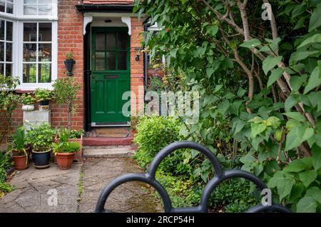 Il cortile anteriore, il giardino e la porta d'ingresso di una campagna in stile inglese, casa di villaggio in estate. Foto Stock