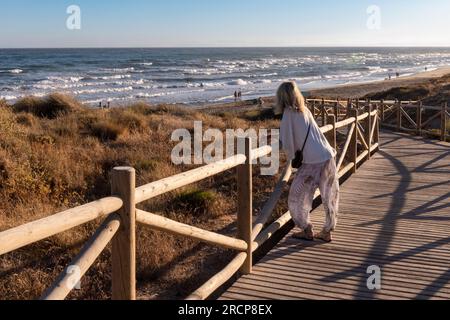 Passeggiata sul lungomare di Artola, accanto a Puerto de Cabopino, Marbella, Costa del Sol, Provincia di Malaga, Andalusia, Spagna meridionale. Le dune di sabbia dietro il bea Foto Stock