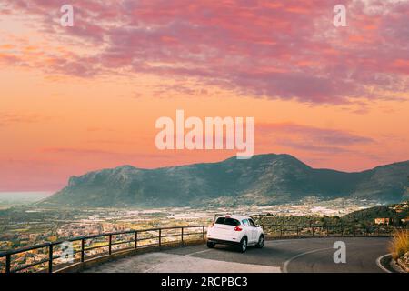 Terracina, Italia. White Color Car on Road su sfondo splendido paesaggio con le montagne in Italia. Foto Stock