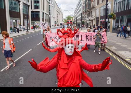 Londra, Regno Unito. 15 luglio 2023. Gli attivisti di Extinction Rebellion noti come Red Rebels si esibiscono durante la protesta a Victoria. Gli attivisti climatici si sono riuniti fuori dal Dipartimento per la sicurezza energetica e Net Zero e hanno marciato verso gli uffici della società energetica Equinor, che gestisce Rosebank, in segno di protesta contro il giacimento di petrolio e gas nel Mare del Nord. (Foto di Vuk Valcic/SOPA Images/Sipa USA) credito: SIPA USA/Alamy Live News Foto Stock