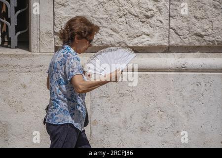 Roma, Italia. 16 luglio 2023 Una donna si tira tifosa in un'altra giornata soffocante con alte temperature a Roma. Il ministero della sanità italiano ha emesso un allarme rosso per le ondate di calore di sedici grandi città italiane, poiché si prevede che la prossima settimana le temperature record raggiungano un picco superiore a 40 °C/104F in un' intensa ondata di caldo che si diffonde nell' Europa meridionale . Credit amer ghazzal/Alamy Live News Foto Stock