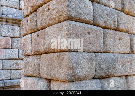 Segovia, Spagna - 11 febbraio 2023: Acquedotto romano. Primo piano delle pietre medievali che fanno parte del supporto o della base. Sono dotati di piccoli fori utilizzati f Foto Stock