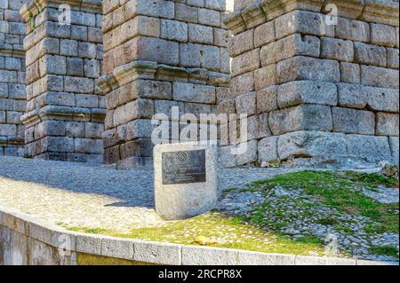 Segovia, Spagna - 11 febbraio 2023: Acquedotto romano. Targa storica che dichiara l'antico acquedotto patrimonio dell'umanità dell'UNESCO. Pietra architettonica c Foto Stock